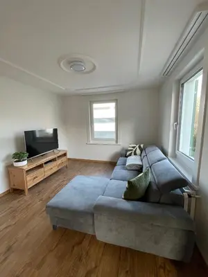 a living room with a couch and a flat screen tv at Charmante Ferienwohnung im Oberthurgau in Amriswil