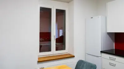 a kitchen with a window and a table and chair at Ninety Apartments in St. Gallen