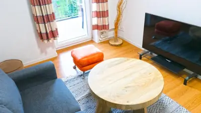 a living room with a table and a tv at Ninety Apartments in St. Gallen