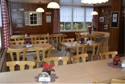 a restaurant with wooden tables and chairs with christmas decorations at Haus Engel Gams in Gams