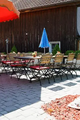 a table and chairs with a blue umbrella on a patio at Haus Engel Gams in Gams