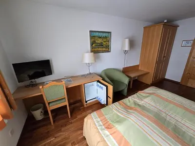 a hotel room with a bed and a desk and a television at Haus Engel Gams in Gams