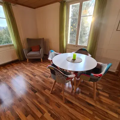 a living room with a table and chairs at Auszeitoase am Wald und Bach in Kradolf