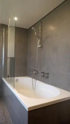 a bathroom with a bath tub with a shower at Mällis Heimetli in Urnäsch