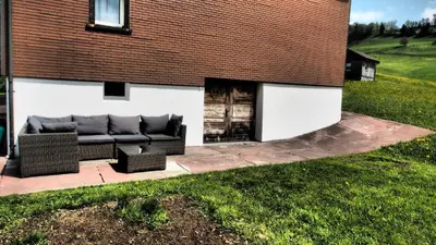 a patio with a couch in front of a building at Mällis Heimetli in Urnäsch