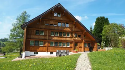 a large wooden house with a pathway in front of it at Mällis Heimetli in Urnäsch