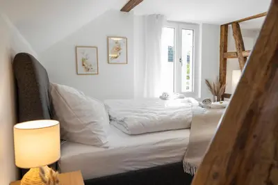 a white bedroom with a bed and a window at Klara 1034 - Olma, Spital, Uni St- Gallen in St. Gallen