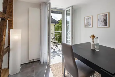 a dining room with a table and a balcony at Klara 1034 - Olma, Spital, Uni St- Gallen in St. Gallen