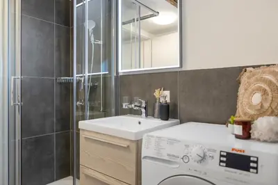 a bathroom with a sink and a washing machine at Klara 1033 - Olma, Spital, Uni St- Gallen in St. Gallen