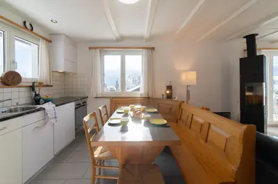 a kitchen with a wooden table and chairs in it at Eldanora in Wildhaus