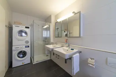 a bathroom with a sink and a washing machine at Saentis in Wildhaus