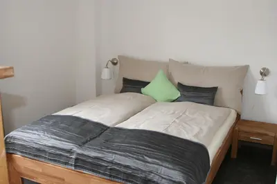 a bed with a green pillow on top of it at Hotel Garni Frohsinn in Uttwil