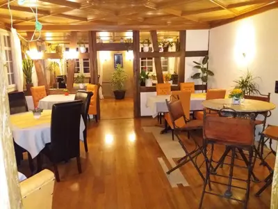 a restaurant with tables and chairs in a room at Hotel Garni Frohsinn in Uttwil