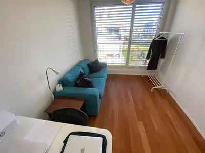 a living room with a blue couch and a window at Mountain View luxury up to four persons in Diepoldsau