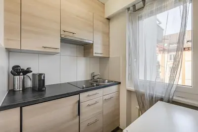 a kitchen with wooden cabinets and a sink at Ferienwohnung mit Balkon W7 in St. Gallen
