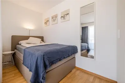 a bedroom with a bed and a mirror at Ferienwohnung mit Balkon W7 in St. Gallen