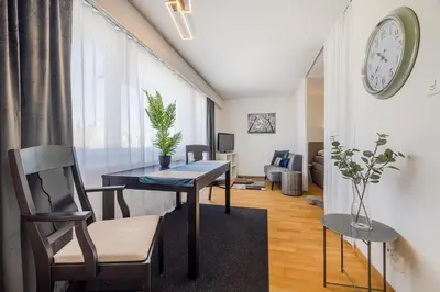 a living room with a table and a tv at Ferienwohnung mit Balkon W7 in St. Gallen