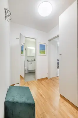 a white room with a green ottoman in the middle at Ferienwohnung mit Balkon W7 in St. Gallen