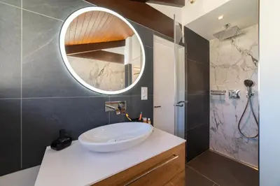 a bathroom with a white sink and a mirror at Alpstern in Wildhaus