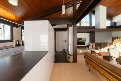 an open kitchen and living room with a couch at Alpstern in Wildhaus