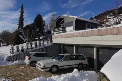 two cars parked outside of a house in the snow at Alpstern in Wildhaus