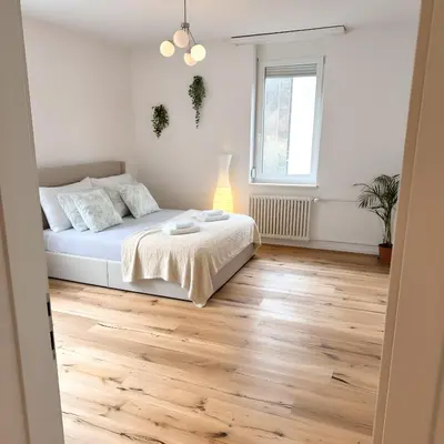 a bedroom with a bed and a wooden floor at Gemütliche und geräumige 2,5 Zimmer Wohnung mit kostenlosem Parkplatz in St. Gallen