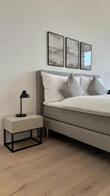 a bedroom with a bed with three pictures on the wall at DESIGN-STUDIO 3 !Gratis Parken, Free Parking! in Kreuzlingen