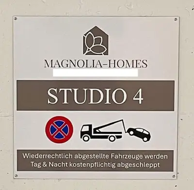 a sign for ahibula homes studio with a car at DESIGN-STUDIO 4 !Gratis Parken, Free Parking! in Kreuzlingen