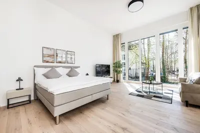 a white bedroom with a bed and a couch at DESIGN-STUDIO 1 !Gratis Parken, Free Parking! in Kreuzlingen