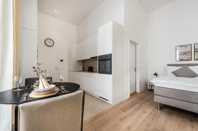 a room with a table and a bed and a kitchen at DESIGN-STUDIO 1 !Gratis Parken, Free Parking! in Kreuzlingen