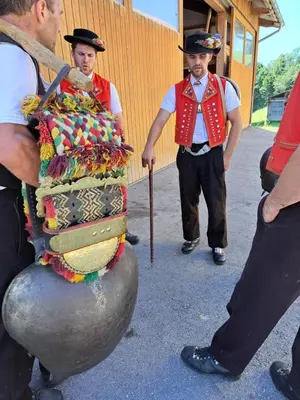 two men dressed in costumes standing next to a large ball at Strickerhof in Hundwil