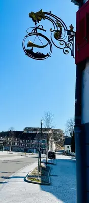a bird perched on a wrought iron sign on a street at Appartement Hörnli Seeliebe in Kreuzlingen