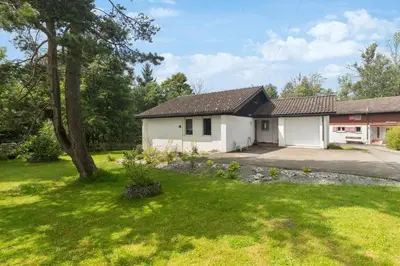 a house with a garage and a grass yard at Chalet Thur in Unterwasser