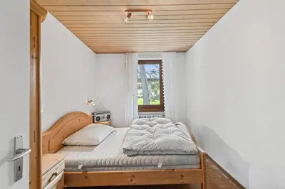 a bedroom with a bed in a room with a window at Chalet Thur in Unterwasser