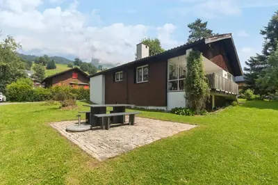 a house with a picnic table in front of it at Chalet Thur in Unterwasser