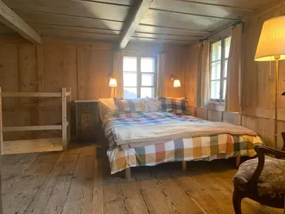 a bedroom with a bed in a wooden room at Private Apartment in Guesthouse Rosalie in Brunnadern