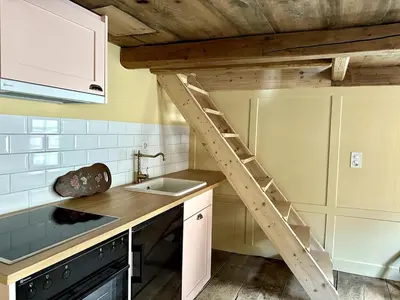 a kitchen with a ladder on the wall above a sink at Private Apartment in Guesthouse Rosalie in Brunnadern
