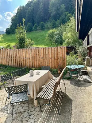 a patio with a table and chairs and a fence at Historic Swiss Room in Guesthouse Rosalie in Brunnadern