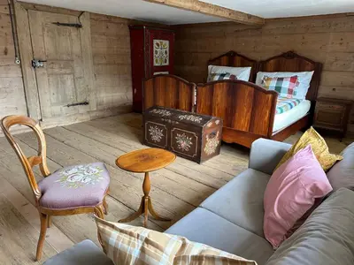 a living room with a couch and a bed at Historic Swiss Room in Guesthouse Rosalie in Brunnadern
