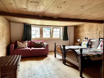 a bedroom with a bed and a couch in a room at Historical Guesthouse Rosalie in Brunnadern