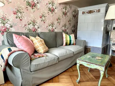 a living room with a gray couch with colorful pillows at Historical Guesthouse Rosalie in Brunnadern