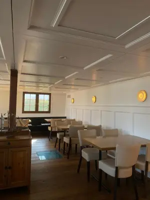 a dining room with tables and white chairs at Schiff Kesswil in Kesswil