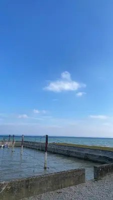 a pier on the beach with the ocean in the background at Schiff Kesswil in Kesswil