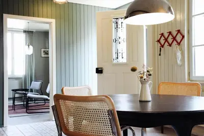 a dining room table with chairs and a vase with flowers at Kaffeegasse 11 - Holiday home with heart on Lake Constance in Altnau