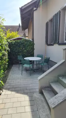 a patio with a table and chairs next to a building at Kaffeegasse 11 - Holiday home with heart on Lake Constance in Altnau