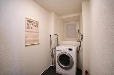 a laundry room with a washing machine and a sign at Klara 0002 - Olma, Spital, Uni St- Gallen in St. Gallen