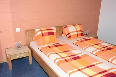 two beds with plaid pillows on them in a room at Towerhotel in Waldkirch