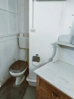 a bathroom with a toilet with a brown seat at Central city apartment with terrace in St. Gallen