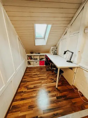 an attic office with a desk and a window at Central city apartment with terrace in St. Gallen