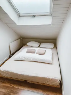 a bed in a small room with a window at Central city apartment with terrace in St. Gallen